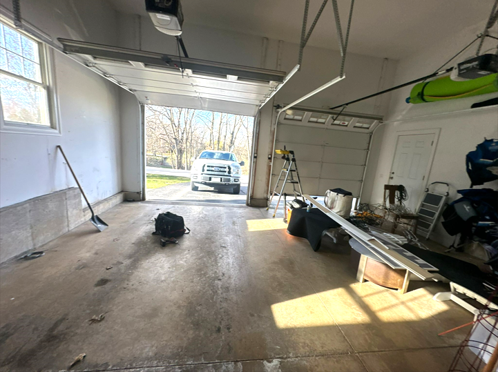 A professional team is performing garage door installation at a residential property in Laurel, Florida, showcasing a precise mechanical and electrical setup.